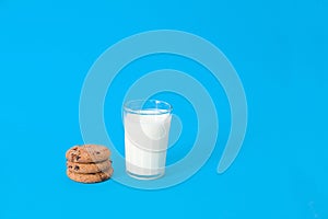 Cookies and glass of milk on blue background. oatmeal cookie with pieces of chocolate