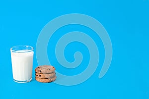 Cookies and glass of milk on blue background. oatmeal cookie with pieces of chocolate