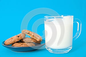 Cookies and glass of milk on blue background. oatmeal cookie with pieces of chocolate