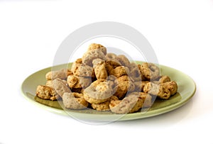 Cookies on a green plate isolated on white background.