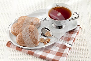 Cookies heart, sugar, spoon, black tea, saucer