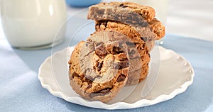 cookies with milk on a blue background. american chocolate chip cookie closeup. pastries on the table. sweets on a plate