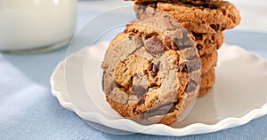 cookies with milk on a blue background. american chocolate chip cookie closeup. pastries on the table. sweets on a plate