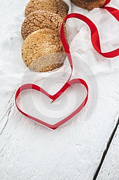 cookies, milk bottle on a white wooden background, and the heart photo