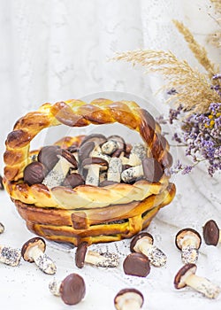 Cookies mushrooms glazed in white and brown chocolate in wicker basket of dough. Dessert. Beautiful