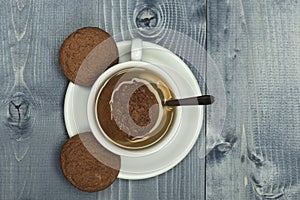 Cookies near tea cup on wooden grey background.