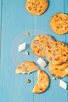 Cookies with nuts and lump sugar on blue wooden table/cookies with nuts and lump sugar on blue wooden table freshly baked. Top