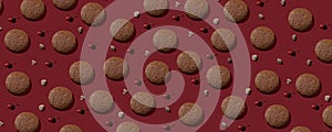 Cookies pattern on the dark red background with cherry and chocolate ingridients. Top view of chocolate chip cookies. Cookies with