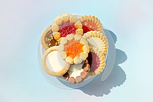 cookies on plate against blue background. round cookies laid out on saucer. copy space, top view