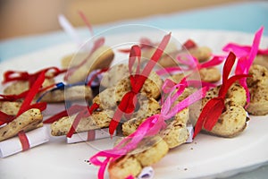 Cookies with regards in the shape of a heart with ribbons.