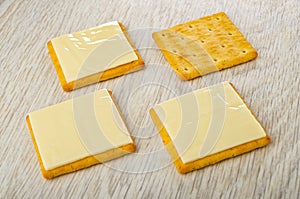 Cookies with slices of melted cheese, cracker on table