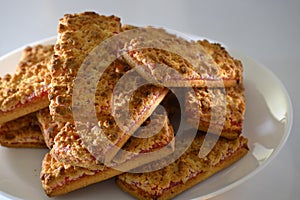 Cookies with strawberry jam on a white plate