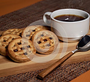 Cookies stuffed with nutella and hot coffee in a wood tone
