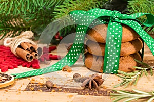 Cookies tied with green ribbon and Christmas decoration, on wooden surface.