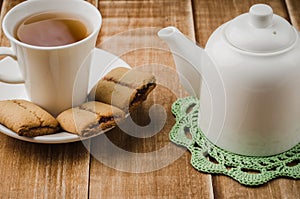 Cookies, white cup of tea and teapot on a wooden background/cookies, white cup of tea and teapot on a wooden background. selective