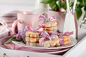 Cookies on a white tray with mugs, milkshakes and lilac flowers