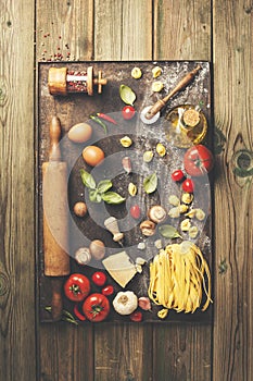 Cooking background: italian ingredients on rustic baking sheet flat lay