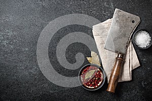 Cooking background with vintage butcher cleaver and spices on bl