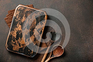 Cooking background with vintage cutting board and wooden spoons