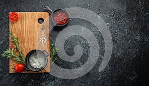 cooking background with wooden cutting board with spices, tomatoes and herbs. Long banner format. top view