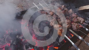 cooking barbecue on charcoal outside, juicy meat, fire extinguished with water from a bottle, a large barbecue and