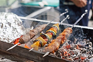 Cooking barbecue on a metal skewer. Mangal with skewered shish kebabs.