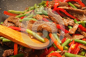 Cooking beef, capsicum and bean stirfry in wok photo