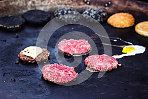 Cooking beef and pork patty with eggs and cheese for burger. Meat roasted on fire barbecue kebabs on the grill. Grilled burger cut