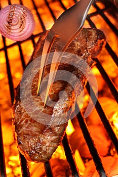 Cooking a beef steak on a barbecue grill