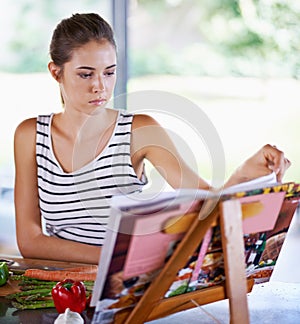 Cooking, book and kitchen with woman, vegetables and vegetarian with recipe and ingredients. Home, girl and person with