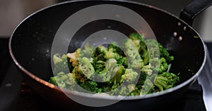 Cooking broccoli florets in a frying pan