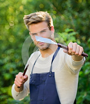 Cooking burgers. Picnic concept. Bbq chef. Handsome guy cooking food. Man hold barbeque equipment. Grilling food