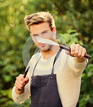 Cooking burgers. Picnic concept. Bbq chef. Handsome guy cooking food. Man hold barbeque equipment. Grilling food