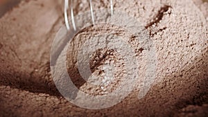 Cooking cake. Mixing flour and cocoa powder in bowl. Close-up.