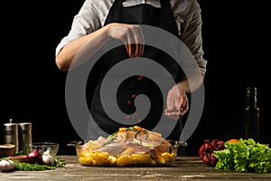 Cooking chef duck sprinkle with grains of pomegranate frozen, horizontal photo, black background