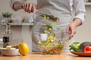 Cooking. The chef is pissed, in the process of a vegetarian salad in the home kitchen. Light background. Restaurant menu, menu,