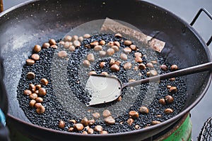 Cooking Chestnuts wiht hot stone sand and coffee bean