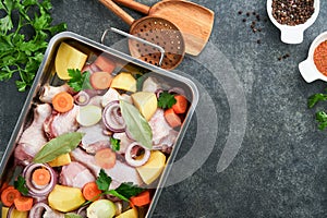 Cooking chicken bouillon or roast in cooking pan or pot with vegetables potatoes, carrots and herbs on kitchen grey concrete