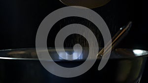 Cooking chocolate cake, a girl sifting cocoa powder through a strainer, close-up, slow-mo