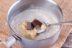 Cooking chocolate oatmeal porridge in a saucepan