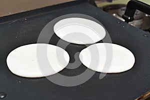 cooking circular round utappam made up of white batter