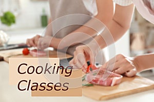 Cooking classes. Blurred view of woman preparing meat on wooden board at table