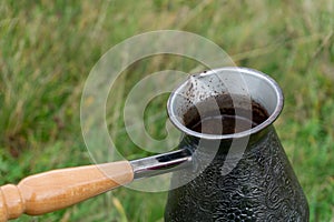 Cooking coffee in the coffee pot outdoors