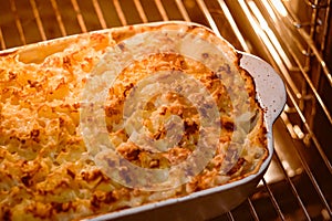 Cooking comfort food and traditional English cuisine, fish pie baking in the oven in countryside kitchen, homemade