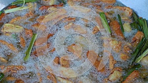 Cooking Concept. Deep-fried fresh banana for Thai snack.  The banana is sliced into pieces and then fried with hot oil in a big ir