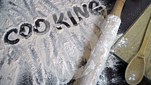 Cooking concept. Finger writting word cooking on wheat flour. Background