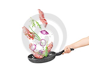 Cooking concept. Vegetables and bacon are falling on a pan isolated o