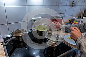 Cooking on cooker in the kitchen with hot steam and pots on a ceran stove to cook delicious meals for the family
