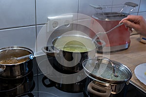 Cooking on cooker in the kitchen with hot steam and pots on a ceran stove to cook delicious meals for the family