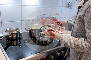 Cooking on cooker in the kitchen with hot steam and pots on a ceran stove to cook delicious meals for the family photo